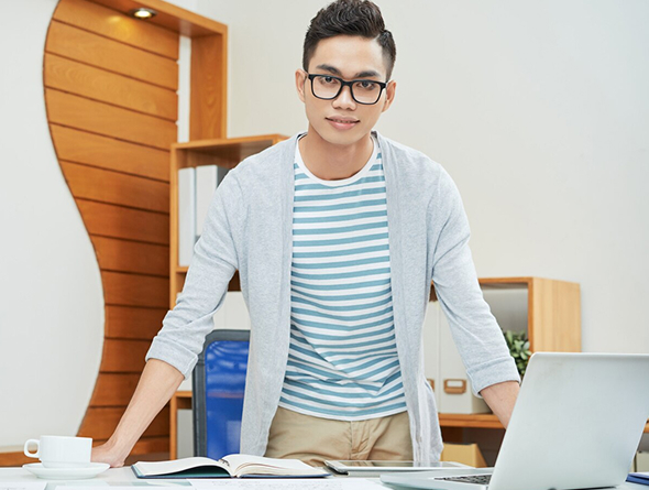 Confident young businessman standing in a modern office environment
